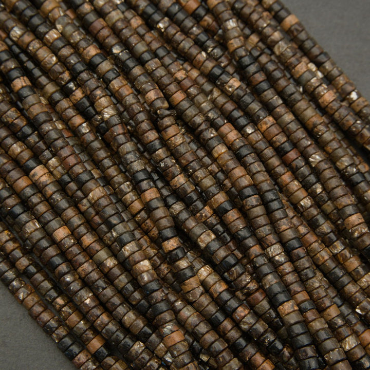 Close-up of natural biotite heishi bead strands showing earthy color variation and textured surfaces.