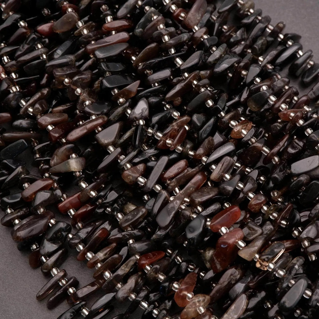 Necklace made of dark beads on a gray background