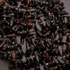 Close-up of dark brown and black beads on a gray background