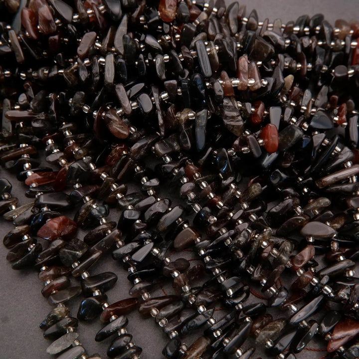 Close-up of dark stone beads on a gray surface