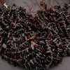 Close-up of dark brown beaded strands on a gray background