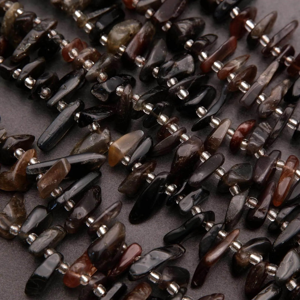 Close-up of dark brown and black stone beads on a textured surface