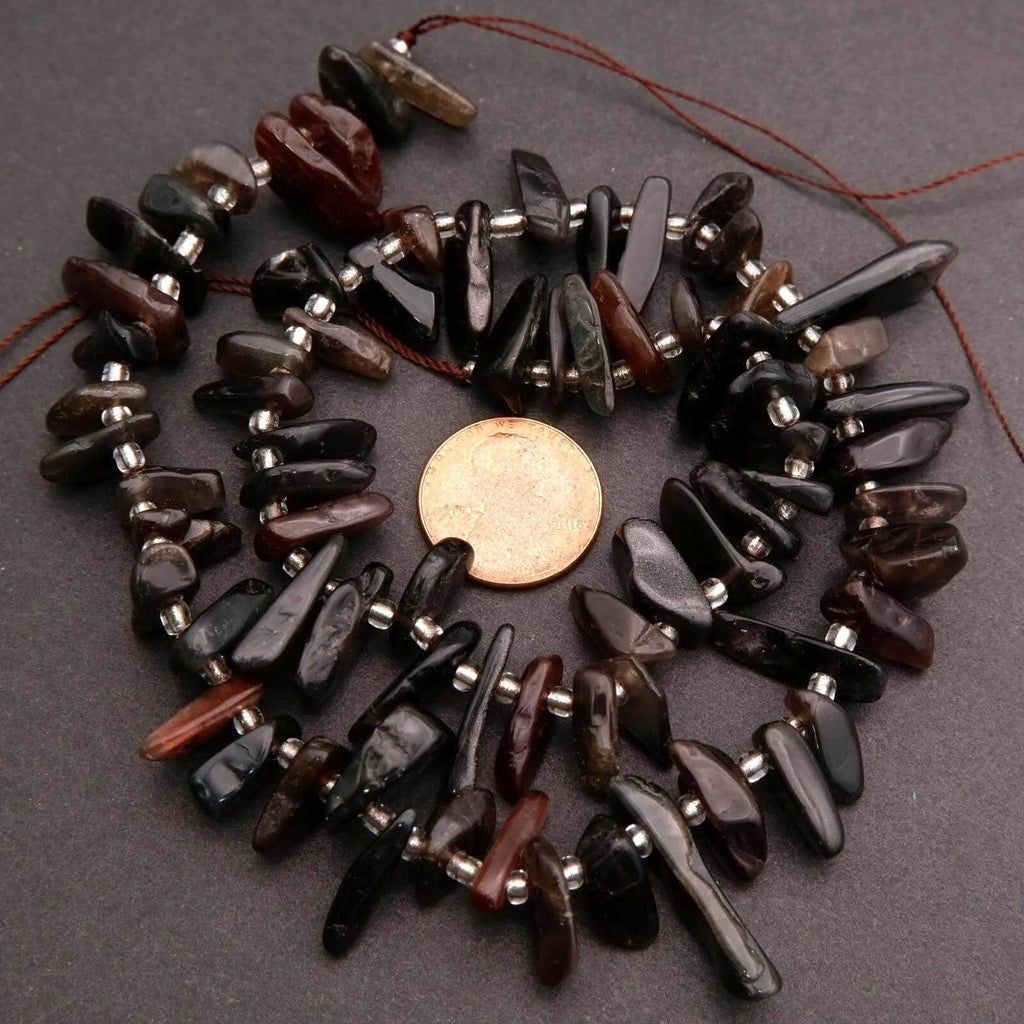 Necklace made of dark beads on a gray background