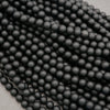 Close-up of black beads arranged in a row on a light gray background