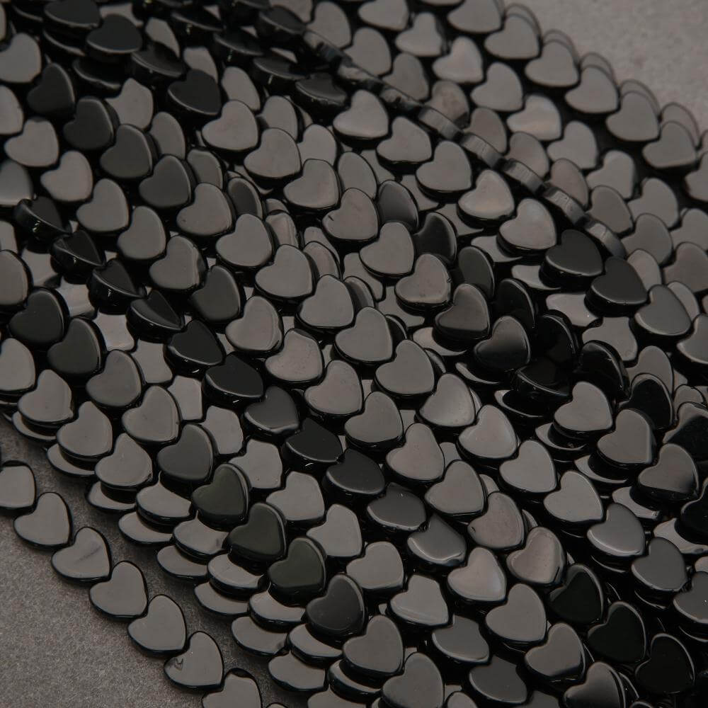 Close-up of black heart-shaped beads on a gray background