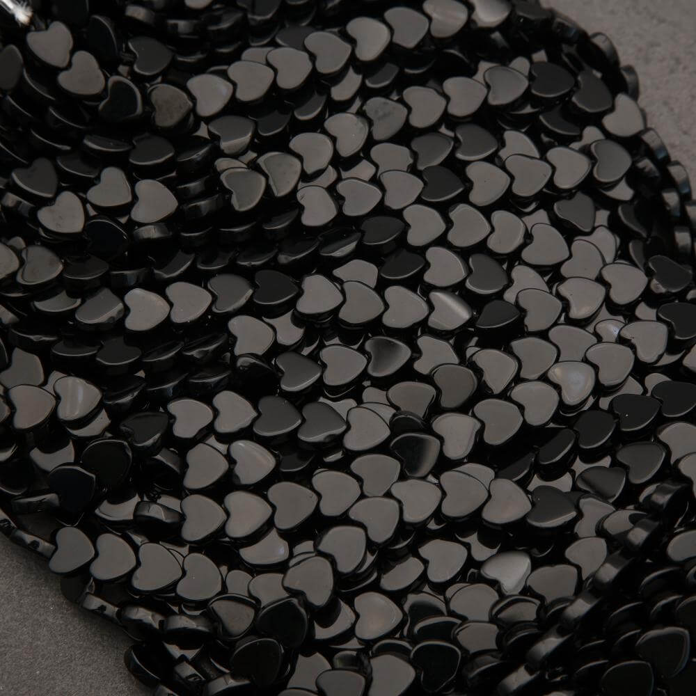 Close-up of black heart-shaped sequins on a textured surface