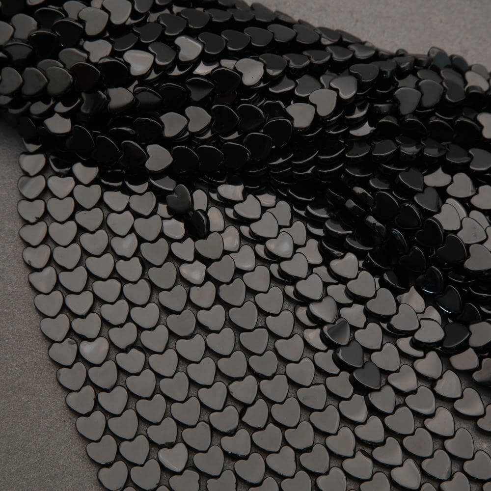 Close-up of black heart-shaped sequins on a gray background
