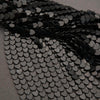 Close-up of black heart-shaped sequins on a gray background