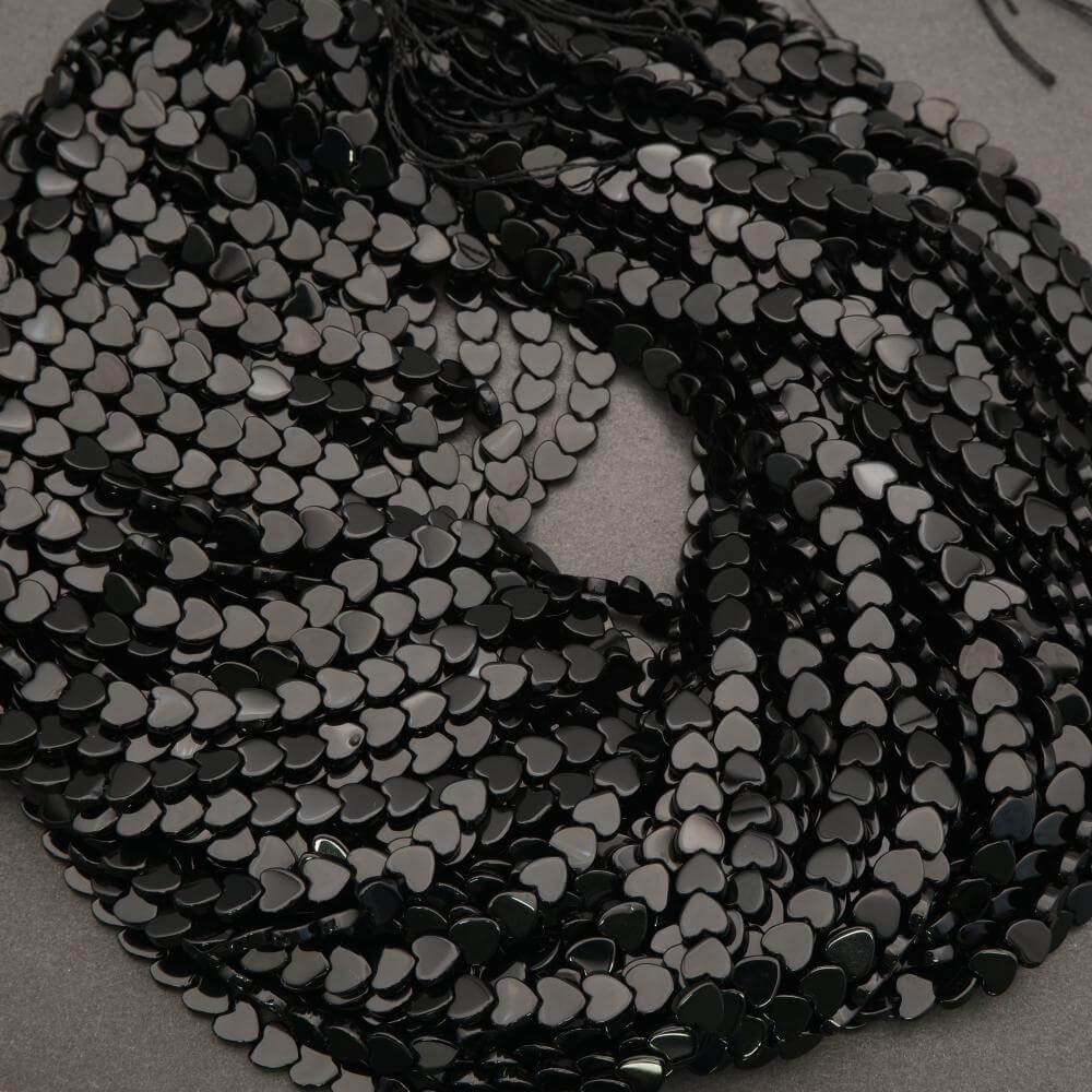 Close-up of black heart-shaped sequins on a gray background