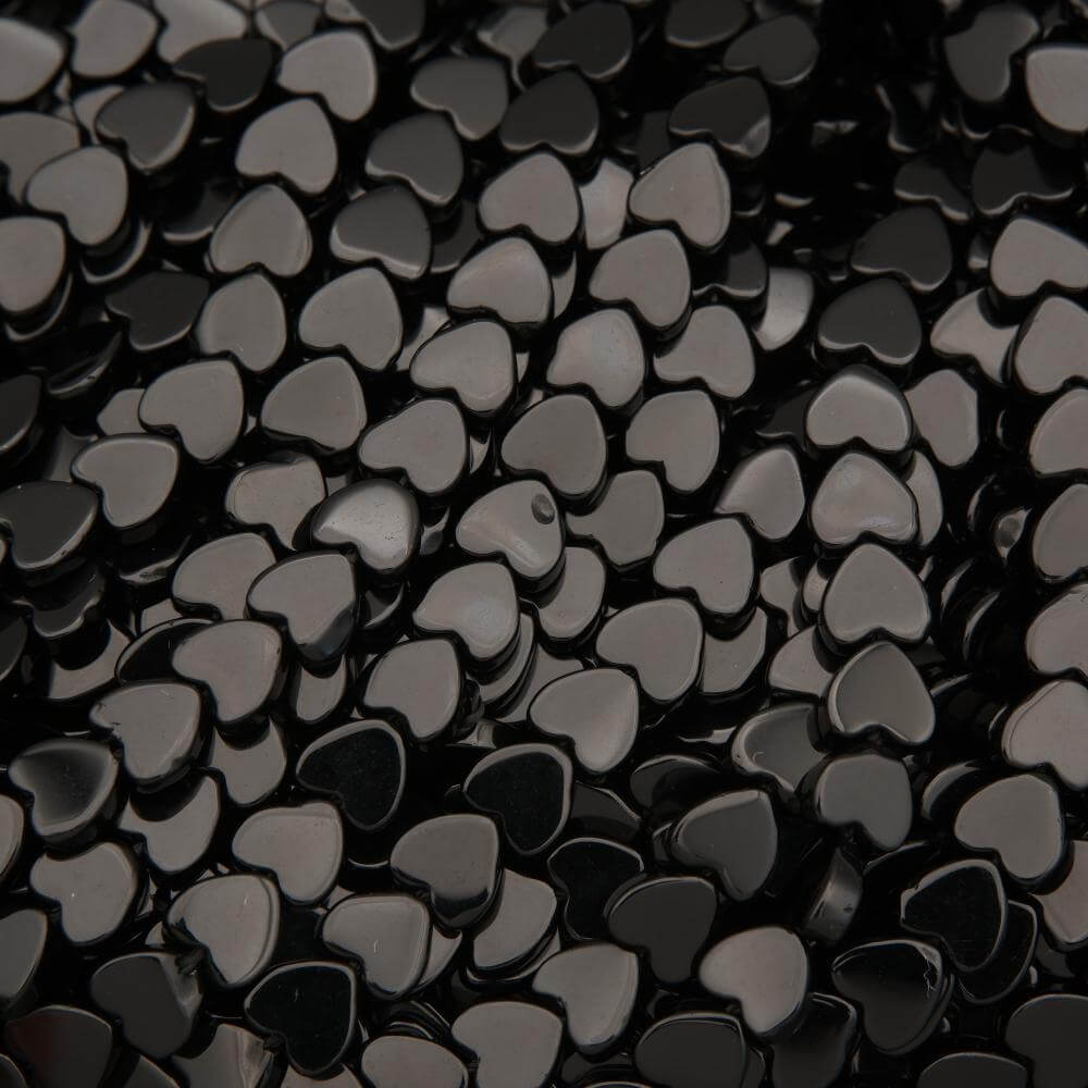 Close-up of black heart-shaped beads on a black background