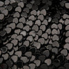 Close-up of black heart-shaped beads on a black background