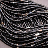 Close-up of black beaded strands on a gray background