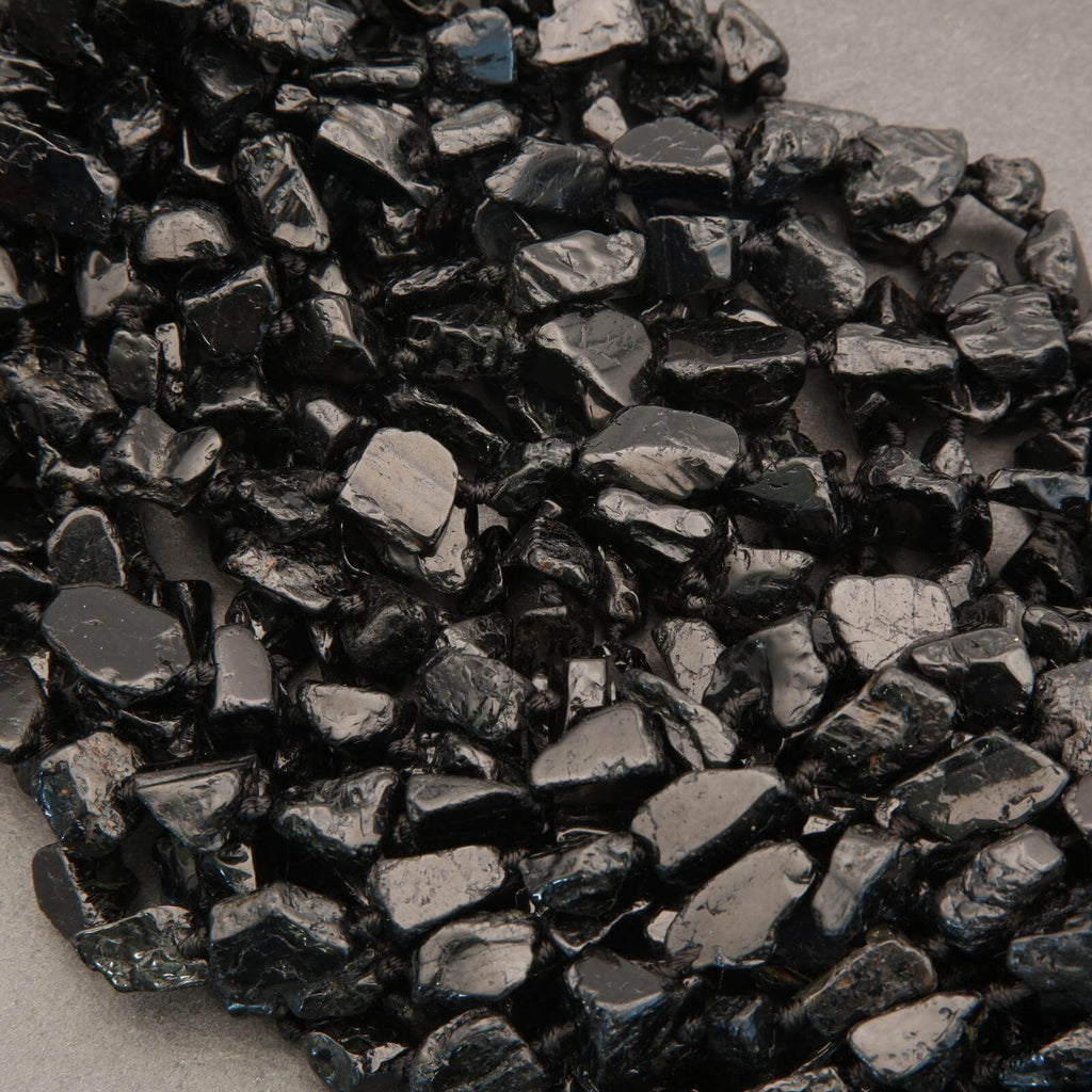 Close-up of dark metallic gravel on a neutral background