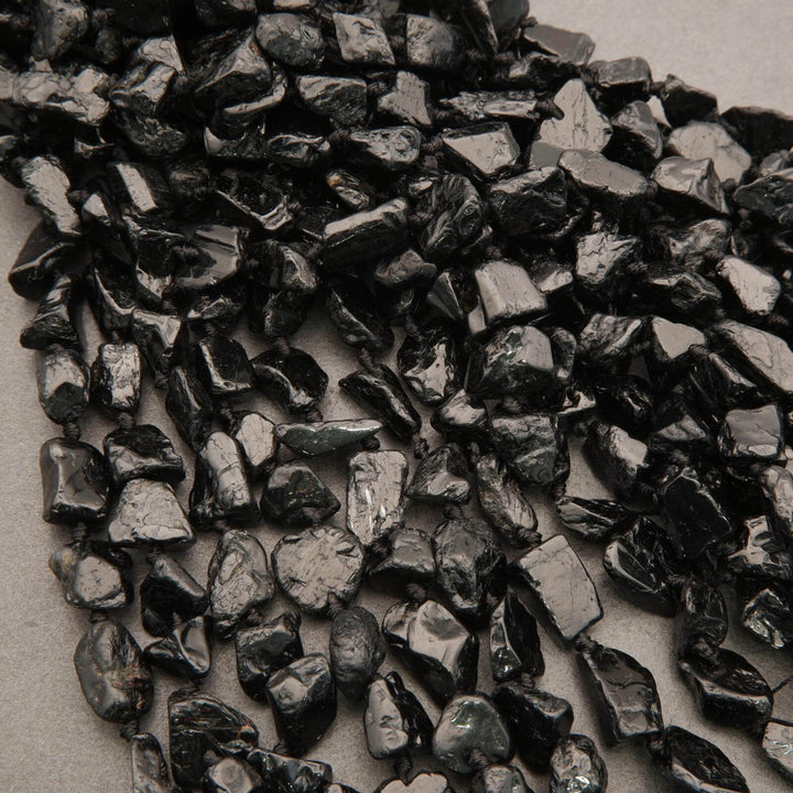 Close-up of dark metallic nuggets on a textured surface