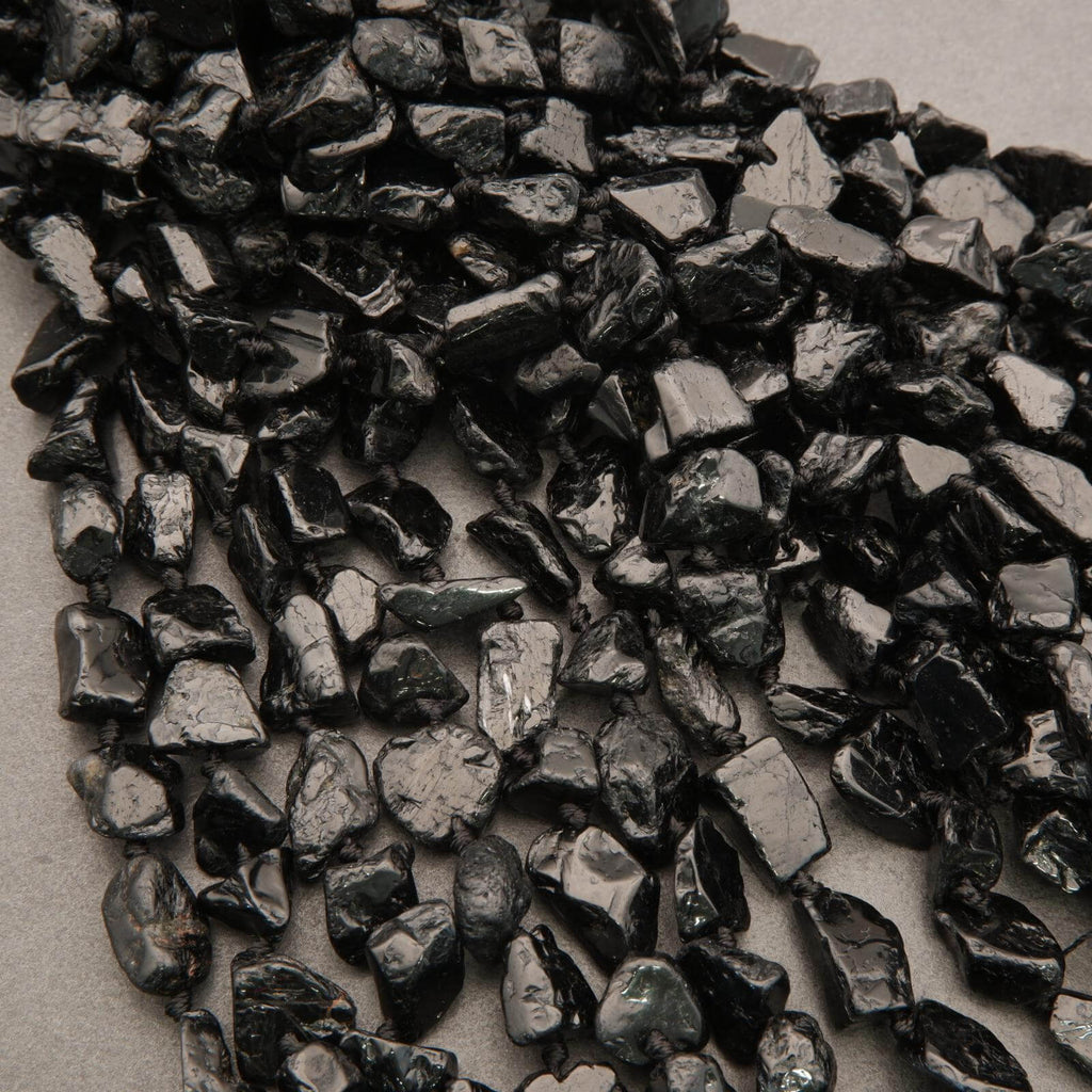 Close-up of dark metallic nuggets on a textured surface