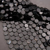 Close-up of black round beads on a gray background