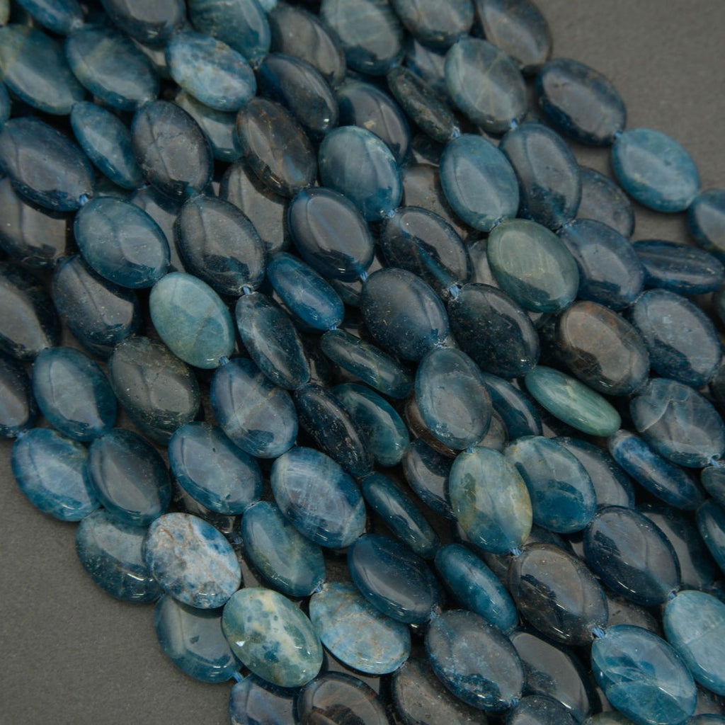 Close-up of blue apatite gemstone beads showing translucent blue tones and smooth polished surfaces.