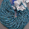 Two strands of blue beads with price tags on a gray background
