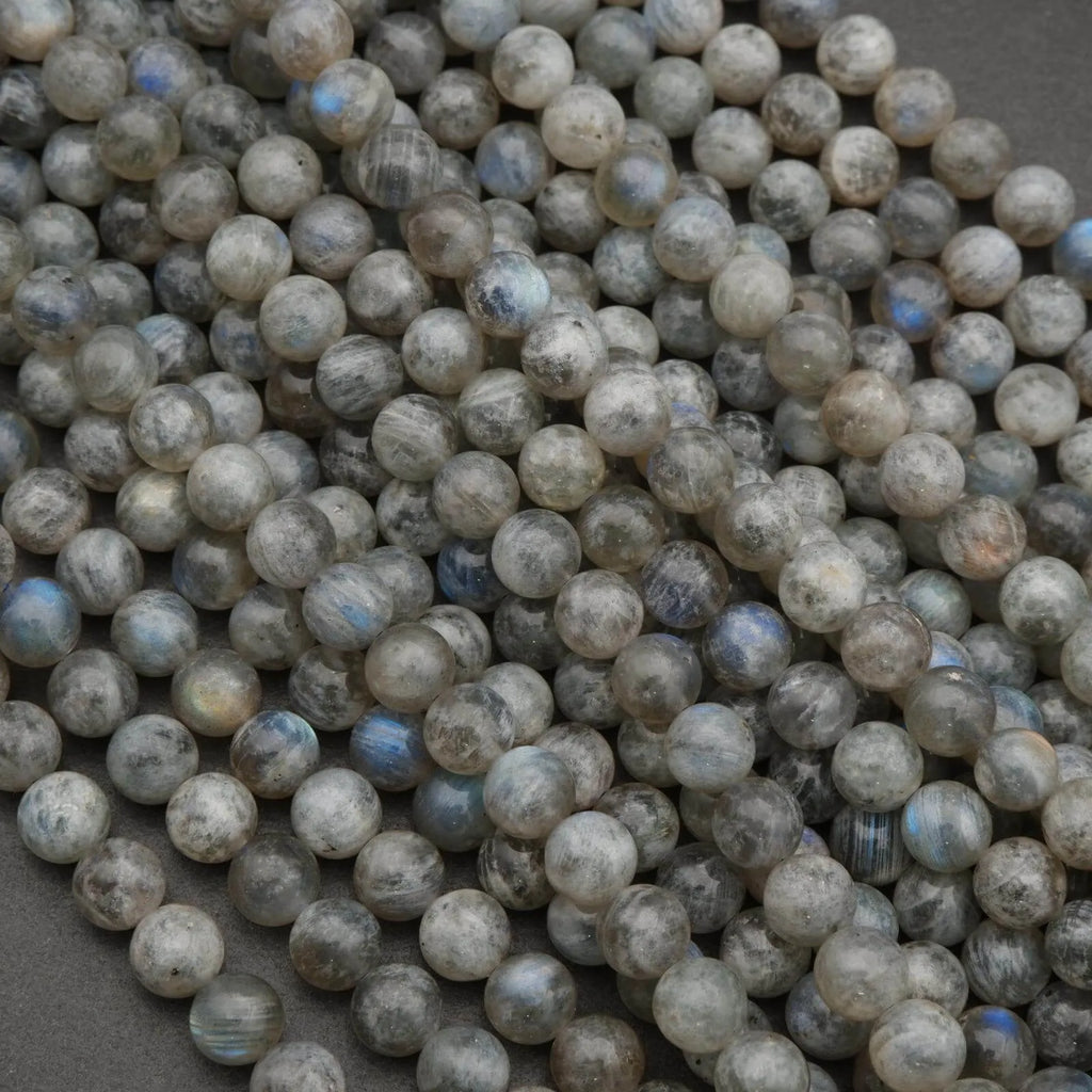 Close-up of round labradorite beads on a dark background
