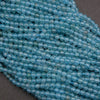 Close-up of a string of light blue beads on a dark surface