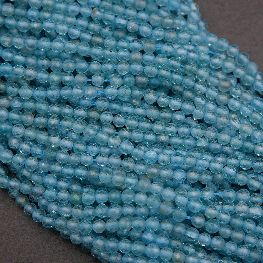 Close-up of a string of light blue beads on a dark surface