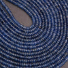 Close-up of a string of blue beads on a gray background