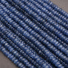 Close-up of blue kyanite beads on a gray background