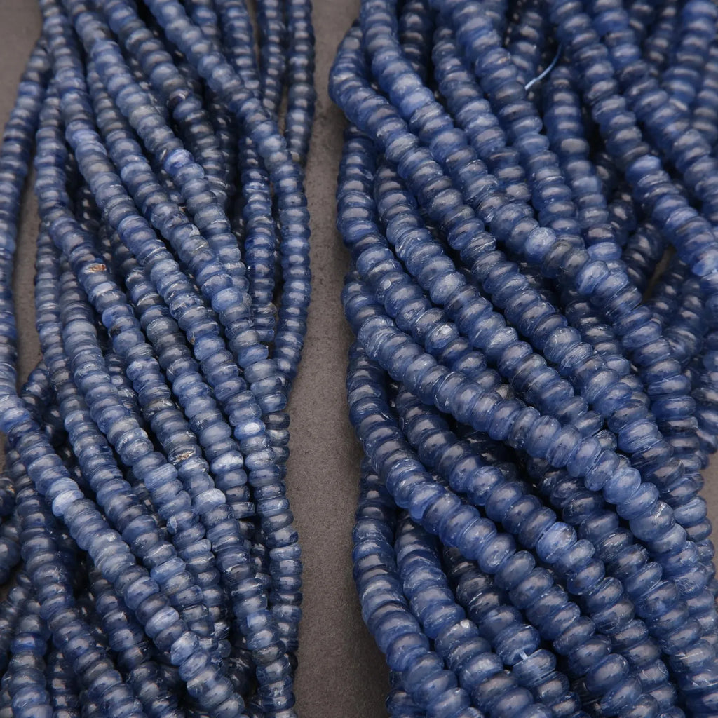Two strands of blue beads on a gray background