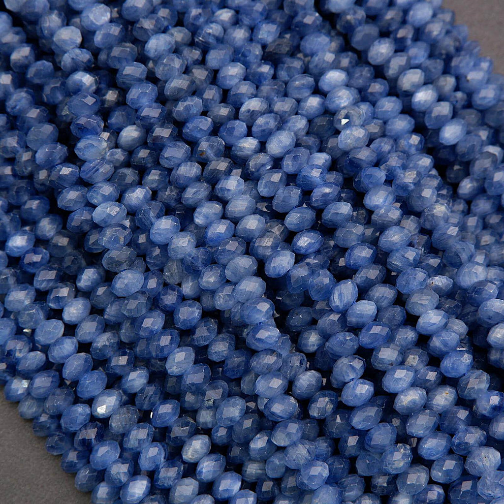 Strands of blue kyanite rondelle beads showing chatoyant texture and sparkling faceted surfaces.