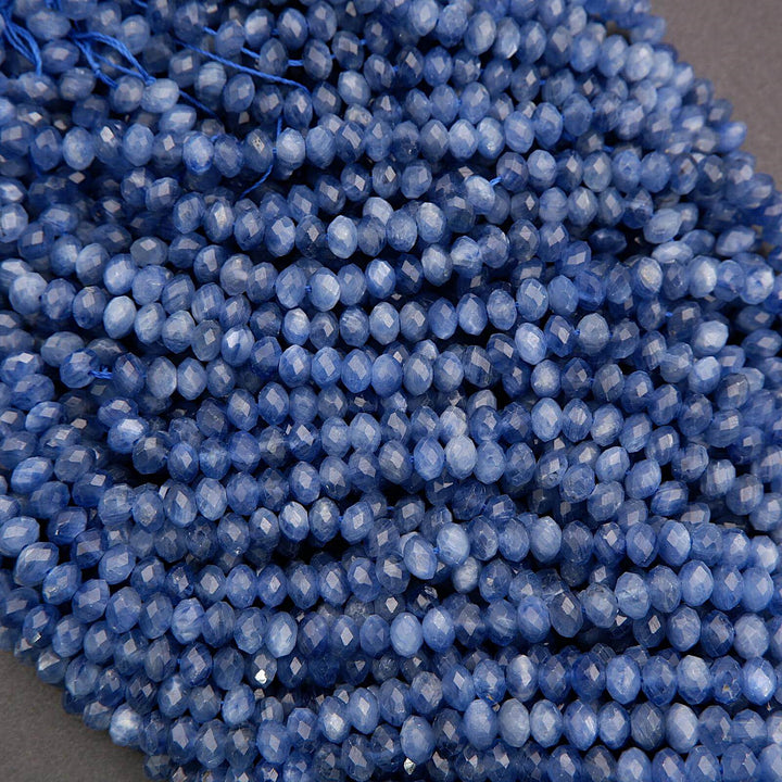 Close-up of polished blue kyanite beads with fibrous patterns and deep blue hues.