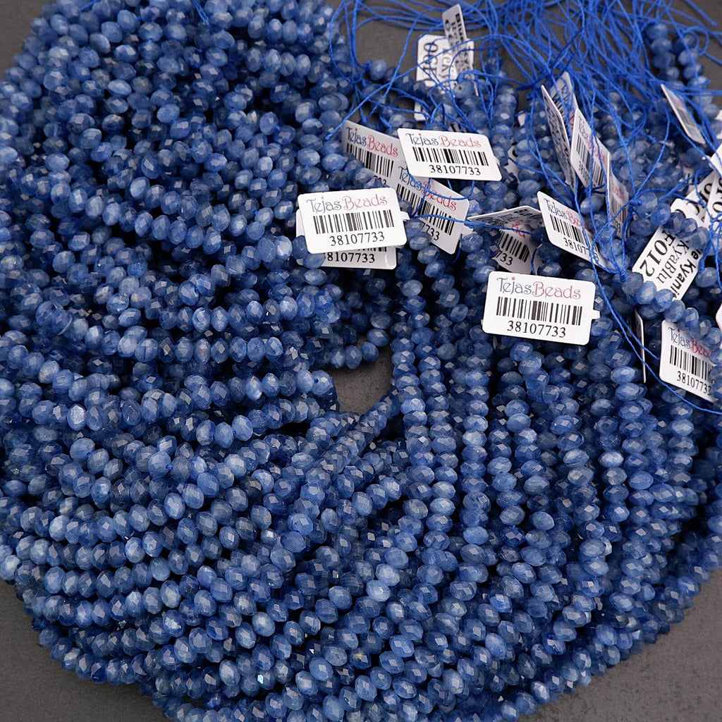 Blue kyanite gemstone beads with reflective facets and characteristic streaked texture.