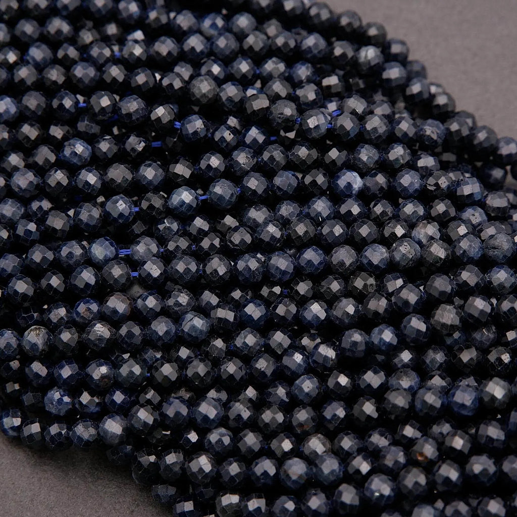 Close-up of dark blue faceted beads on a gray background