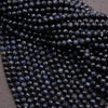 Close-up of dark blue faceted beads on a gray background