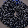 Coiled string of dark blue beads on a gray background