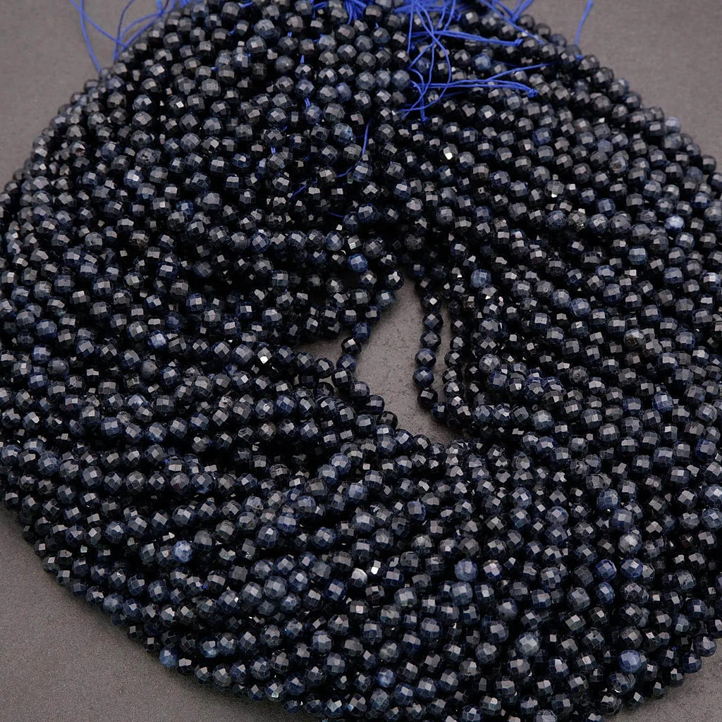 Coiled string of dark blue beads on a gray background