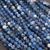Close-up of blue and white marbled beads on a dark surface
