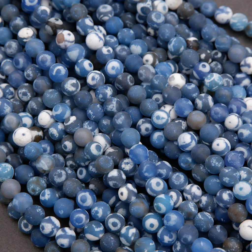 Close-up of blue and white marbled beads on a dark surface