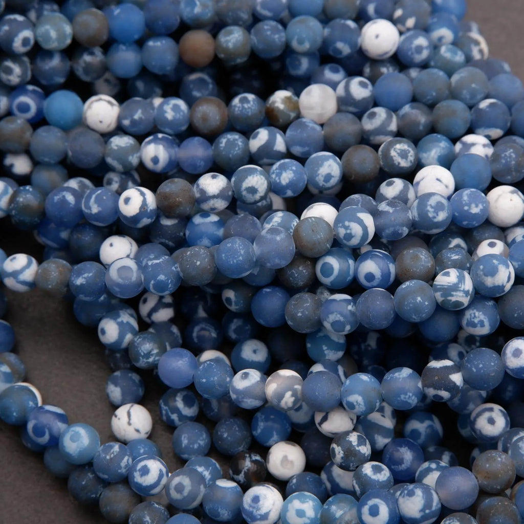 Close-up of blue and white marbled beads on a dark background