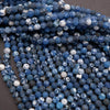 Close-up of blue and white marbled beads on a dark surface