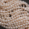 Close-up of a pile of light pink pearls on a dark background