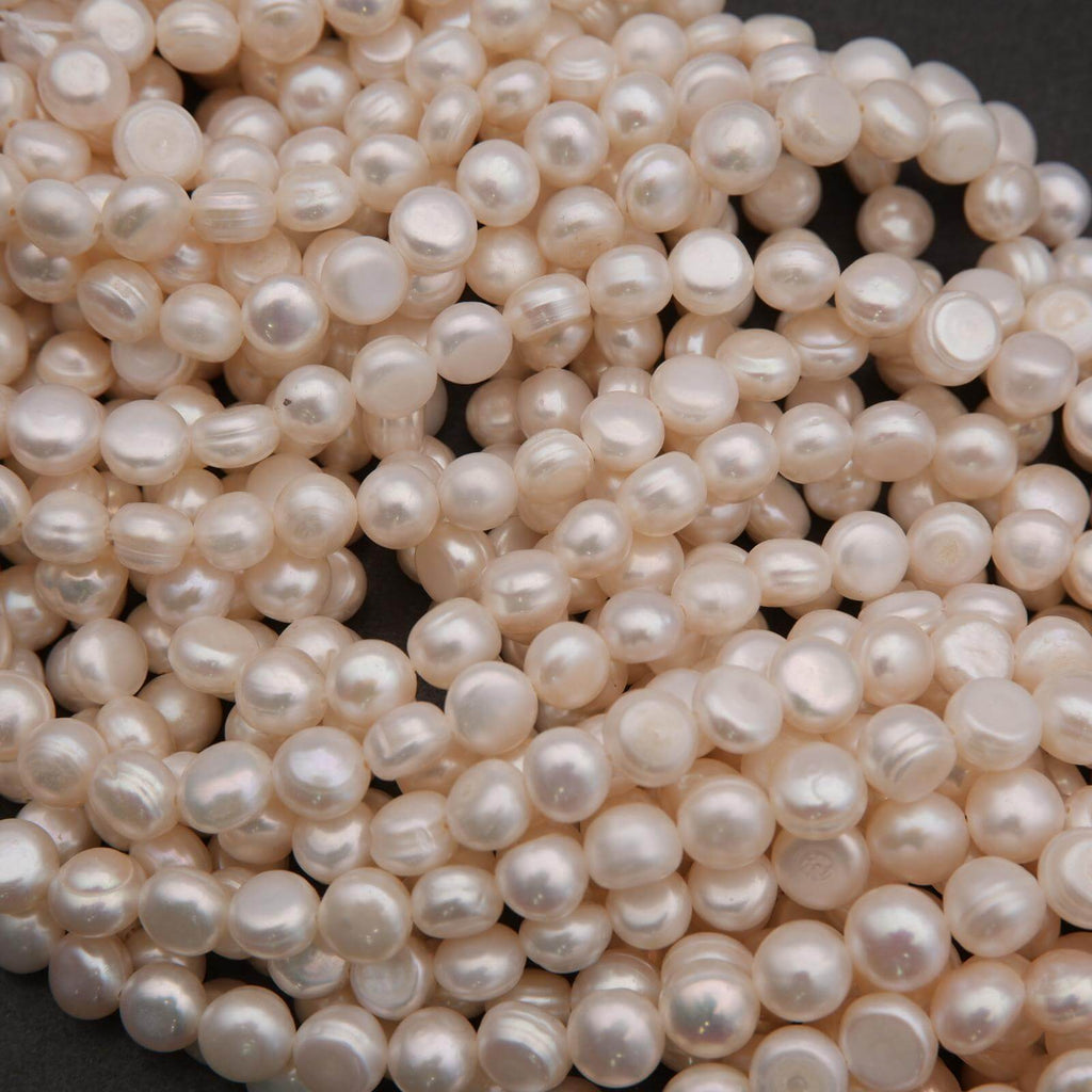 Close-up of a pile of light pink pearls on a dark background