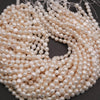 Close-up of a coil of white pearl beads on a dark background