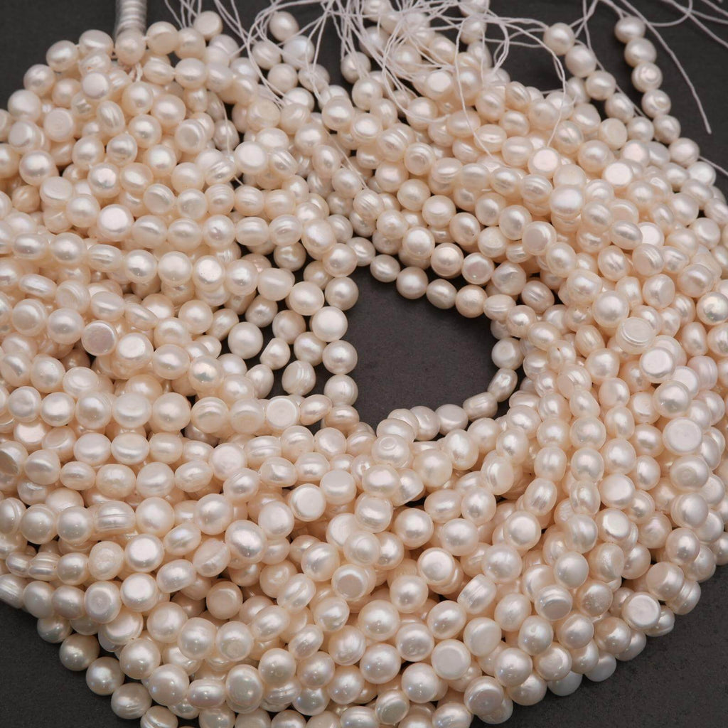 Close-up of a coil of white pearl beads on a dark background