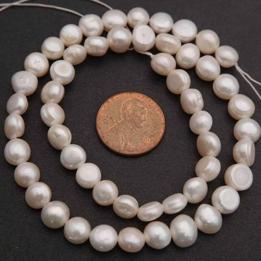 String of pearls with a penny for scale on a dark background