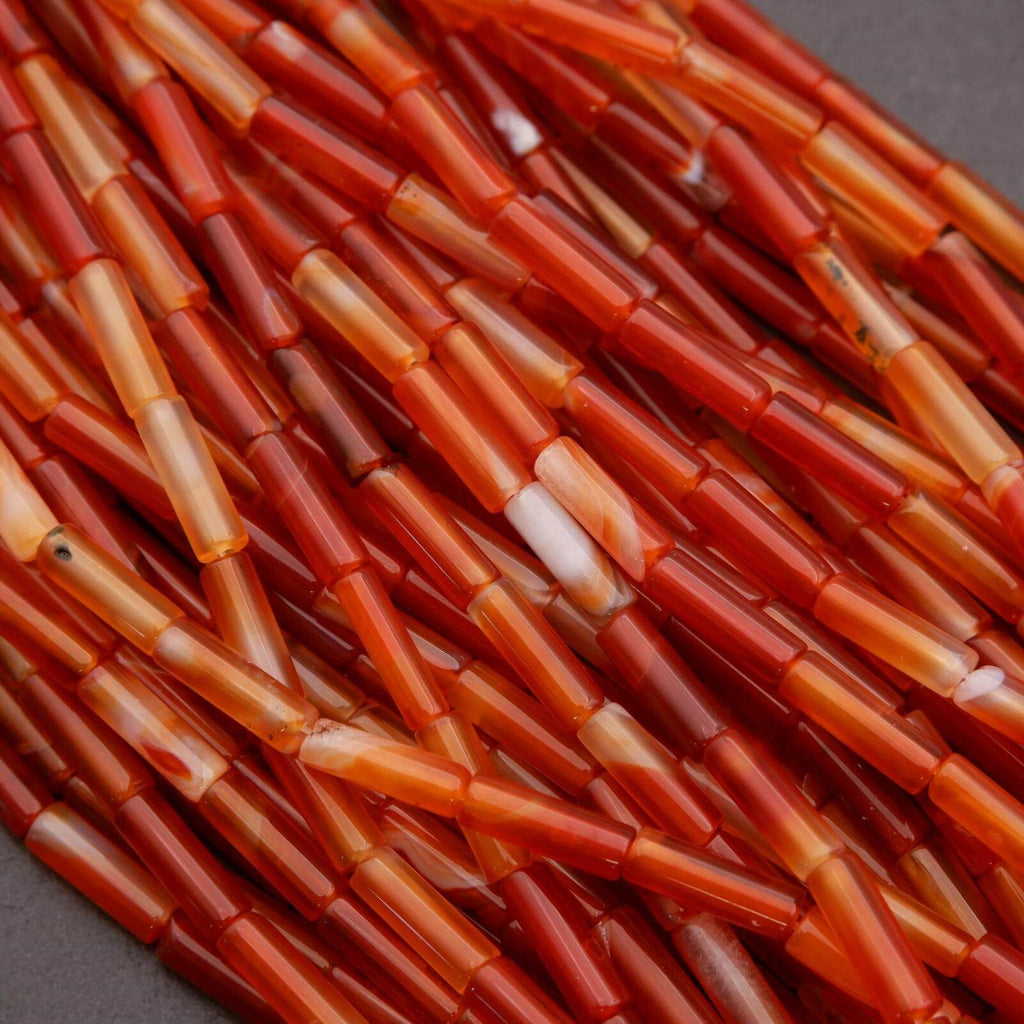 Close-up of orange and red cylindrical beads on a dark background