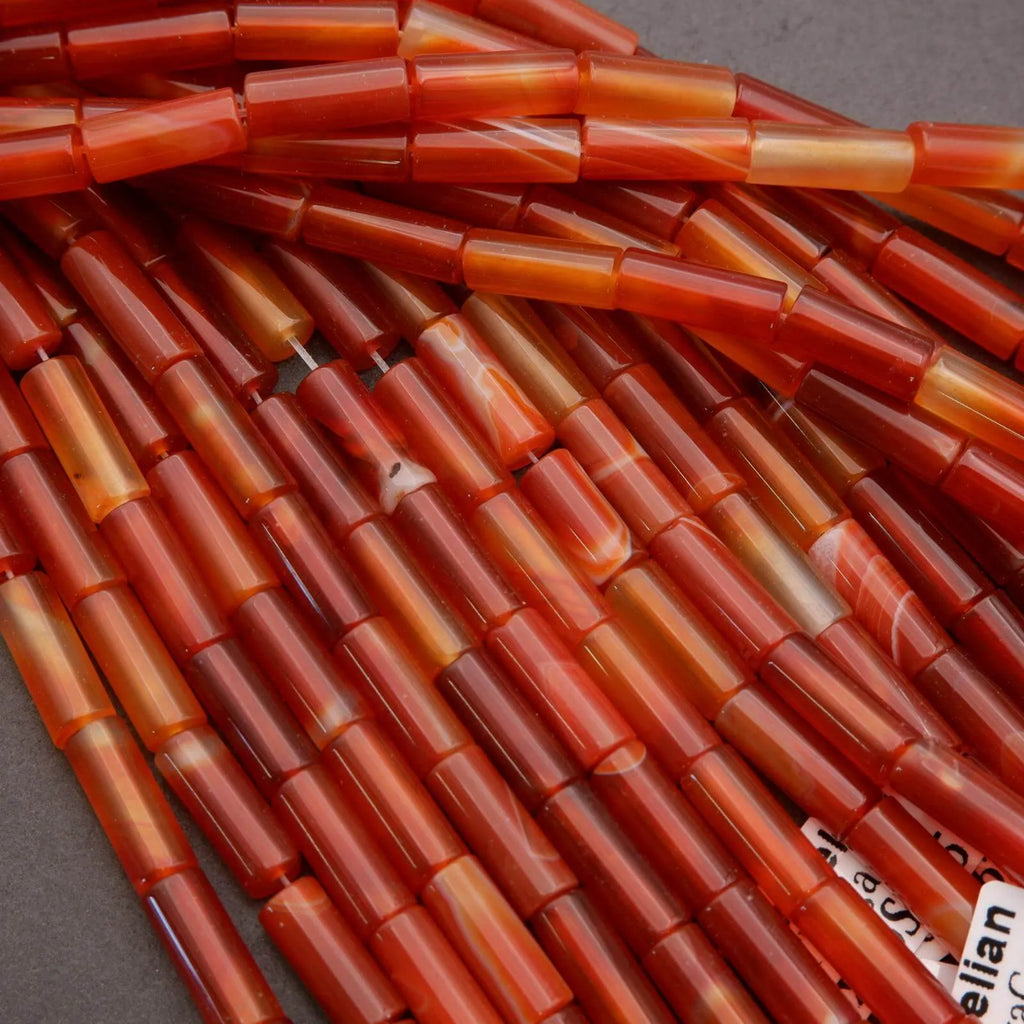 Close-up of red and orange cylindrical beads on a gray background