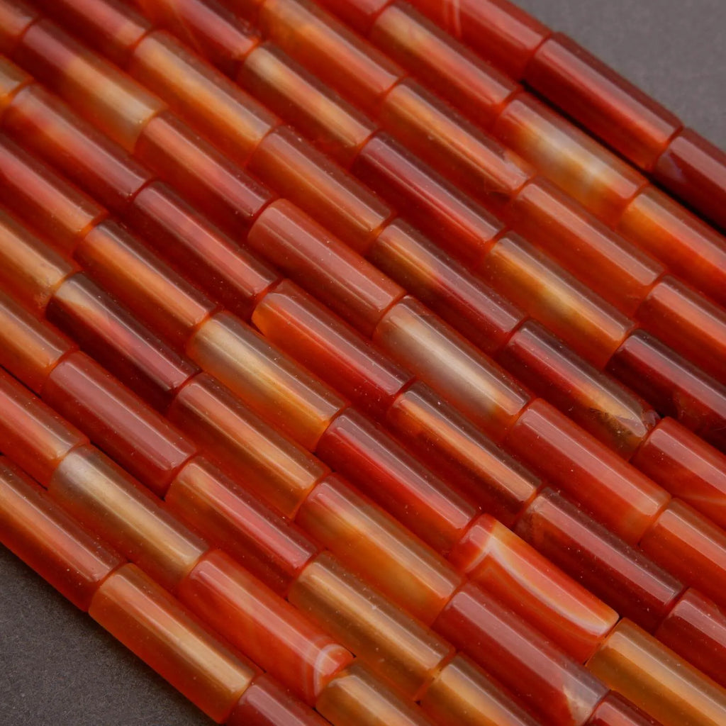 Close-up of red and orange cylindrical beads on a dark background