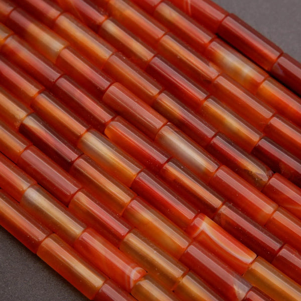 Close-up of red and orange cylindrical beads on a dark background