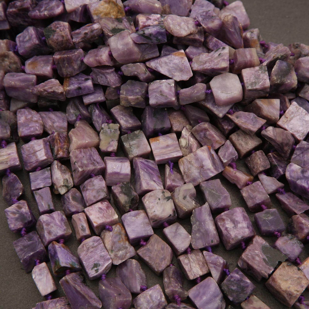 Close-up of purple and green stone beads on a dark background