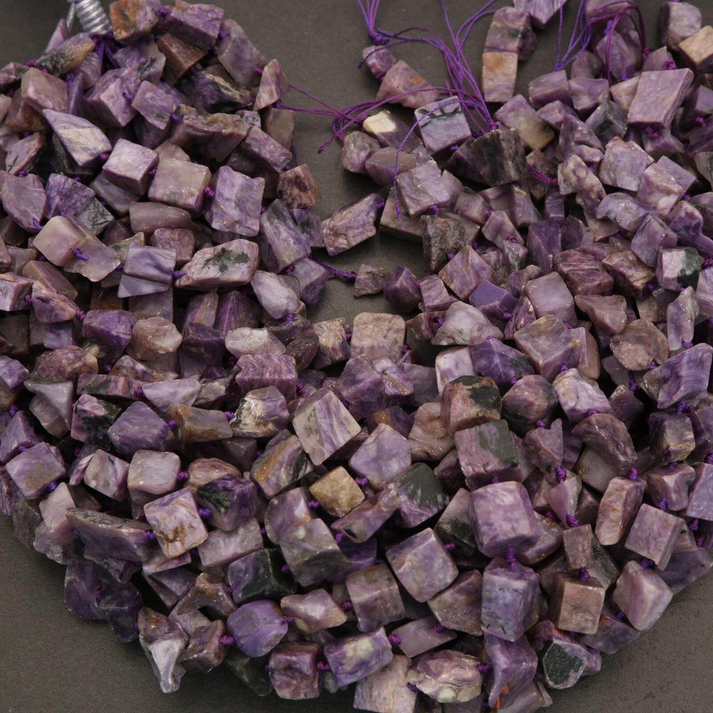 Close-up of a necklace made from purple and gray stone beads on a dark surface.